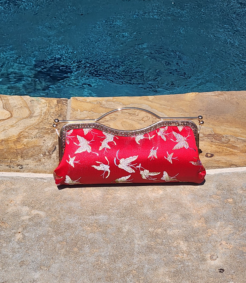 Nola & Eve Crimson Serenity clutch in vibrant red brocade with delicate butterfly embroidery, handmade limited-edition statement bag