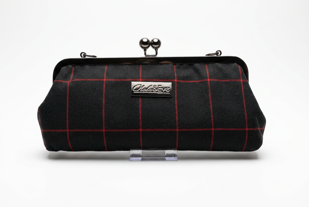 Nola & Eve Midnight Regent clutch in black fabric with crimson windowpane pattern and black metal kiss-lock frame, handmade limited-edition statement bag