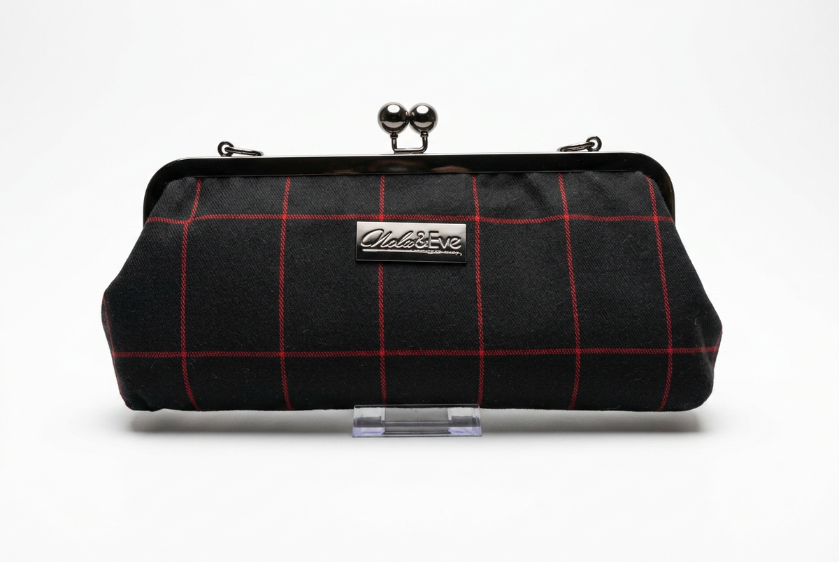 Nola & Eve Midnight Regent clutch in black fabric with crimson windowpane pattern and black metal kiss-lock frame, handmade limited-edition statement bag